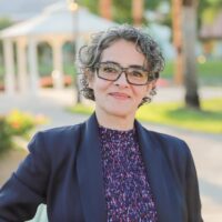 candidate with blue jacket and purple shirt and black glasses