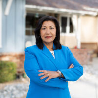 candidate with blue jacket and arms crossed