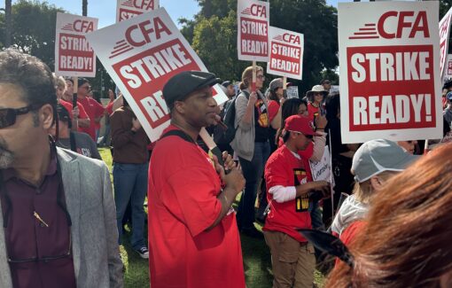 People standing in grass and on sidewalk carrying "CFA Strike Ready!" signs.