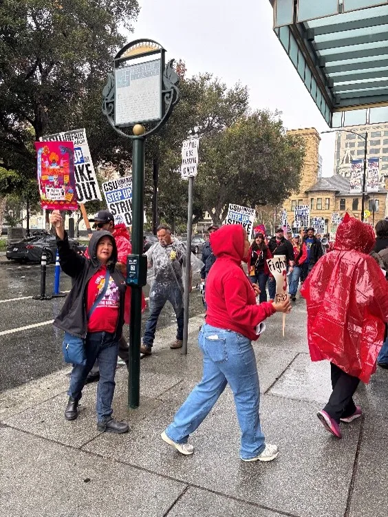 A group of people picket in front of a hotel where the chancellor was speaking.