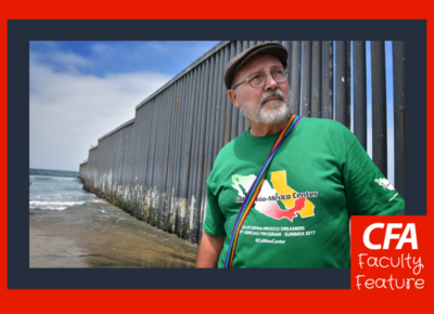 A man stands in front of the shore wearing a California-Mexico Dreamers shirt.