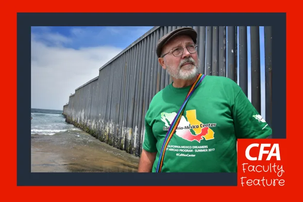 A man stands in front of the shore wearing a California-Mexico Dreamers shirt.