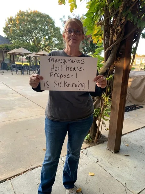 A faculty member holds up a sign that reads: "Management's healthcare proposal is sickening!"