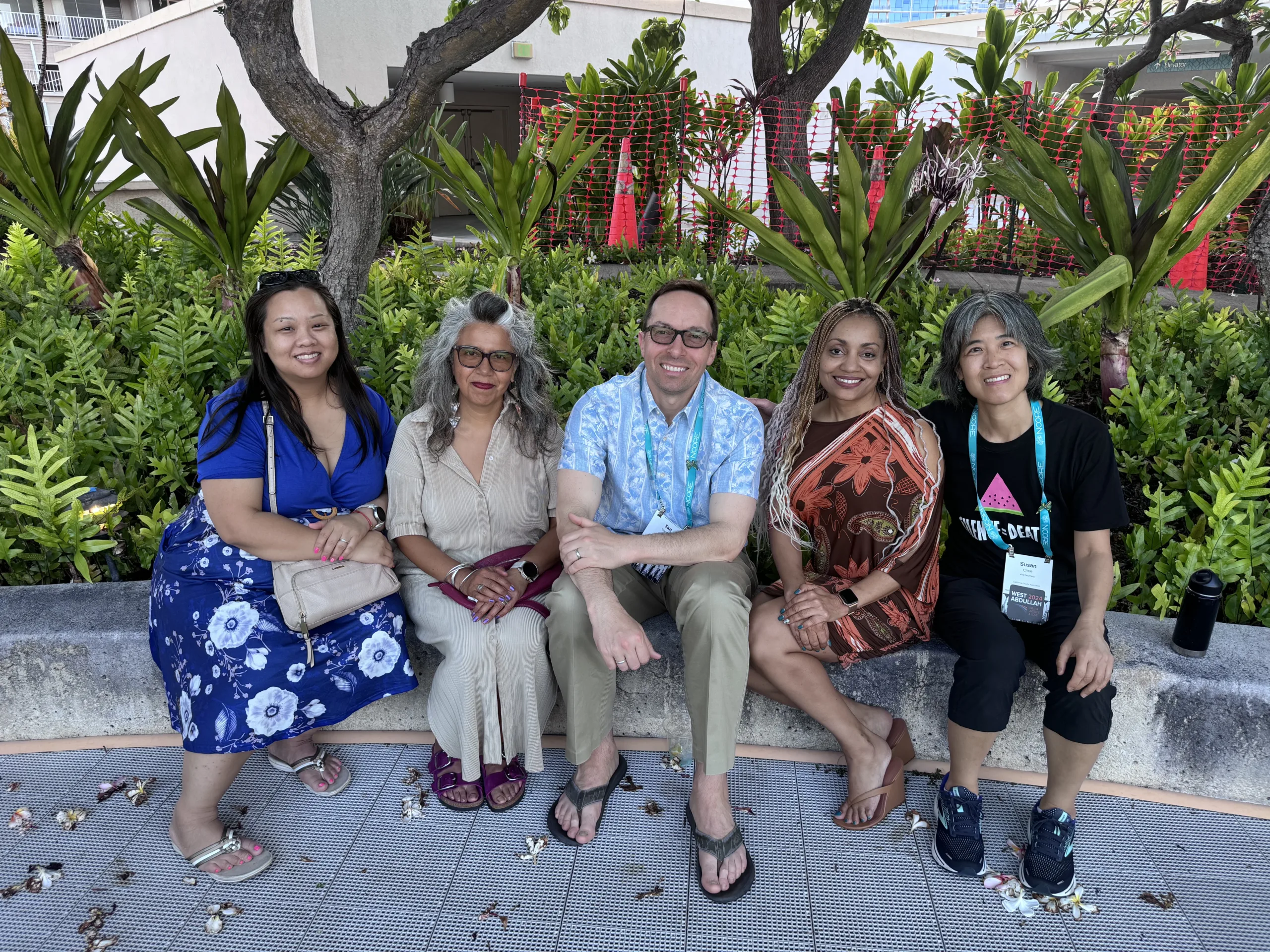A group of counselors sit down together outside.